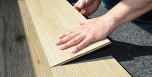 Handwerker verlegt Laminatboden – präzise Anpassung und professionelle Bodenmontage.